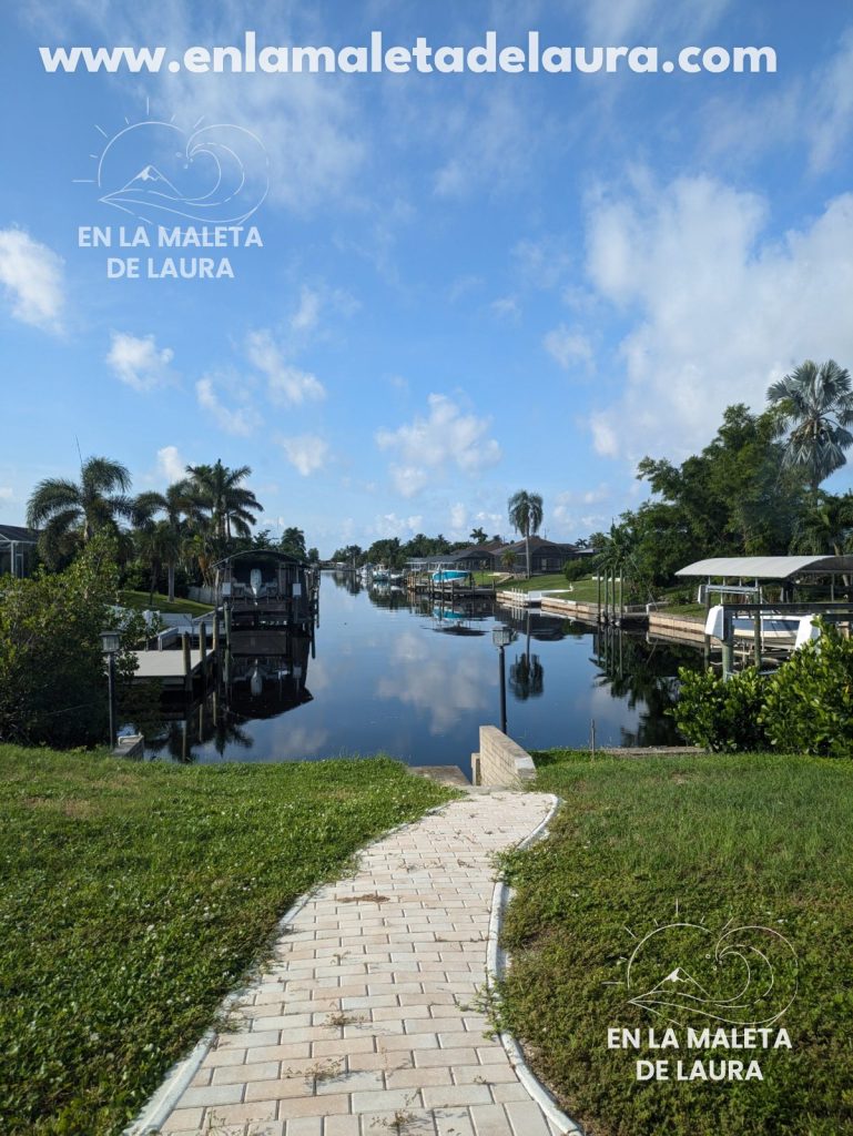 Canal residencial de Cape Coral con barcos amarrados y palmeras reflejadas en el agua