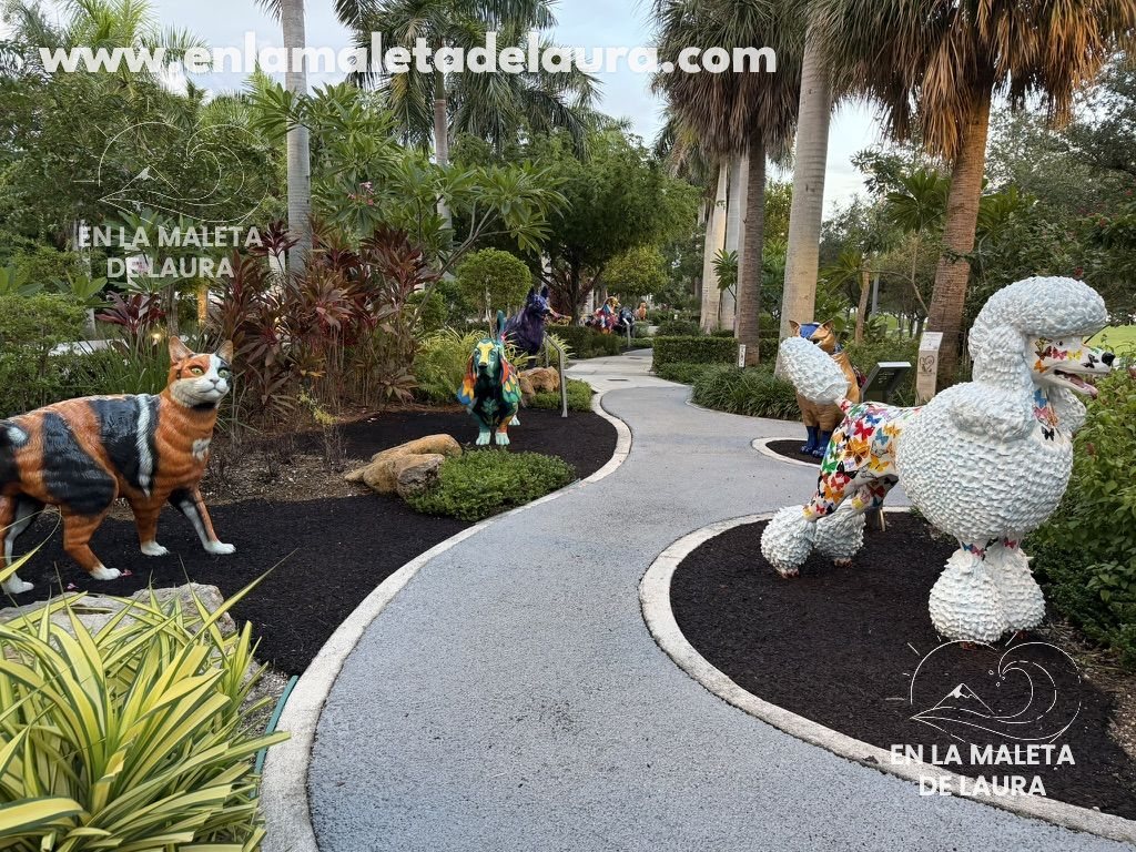 Esculturas de un perro y un gato entre plantas en el Dogs & Cats Walkway